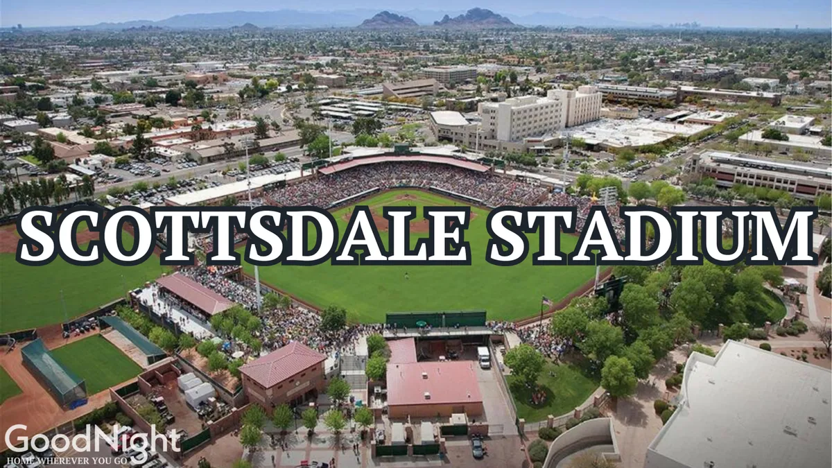 This exterior image captures the vibrant scene at Scottsdale Stadium, featuring a crowd of spectators enjoying a baseball game. The baseball field is clearly visible, surrounded by a lively atmosphere and the local landscape.