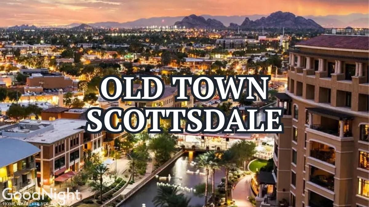 A lively view of Old Town Scottsdale featuring the scenic waterway, mountain backdrop, and vibrant streetscape. The area is bustling with activity, suggesting outdoor dining, shopping, and evening strolls in a pet-friendly urban environment.
