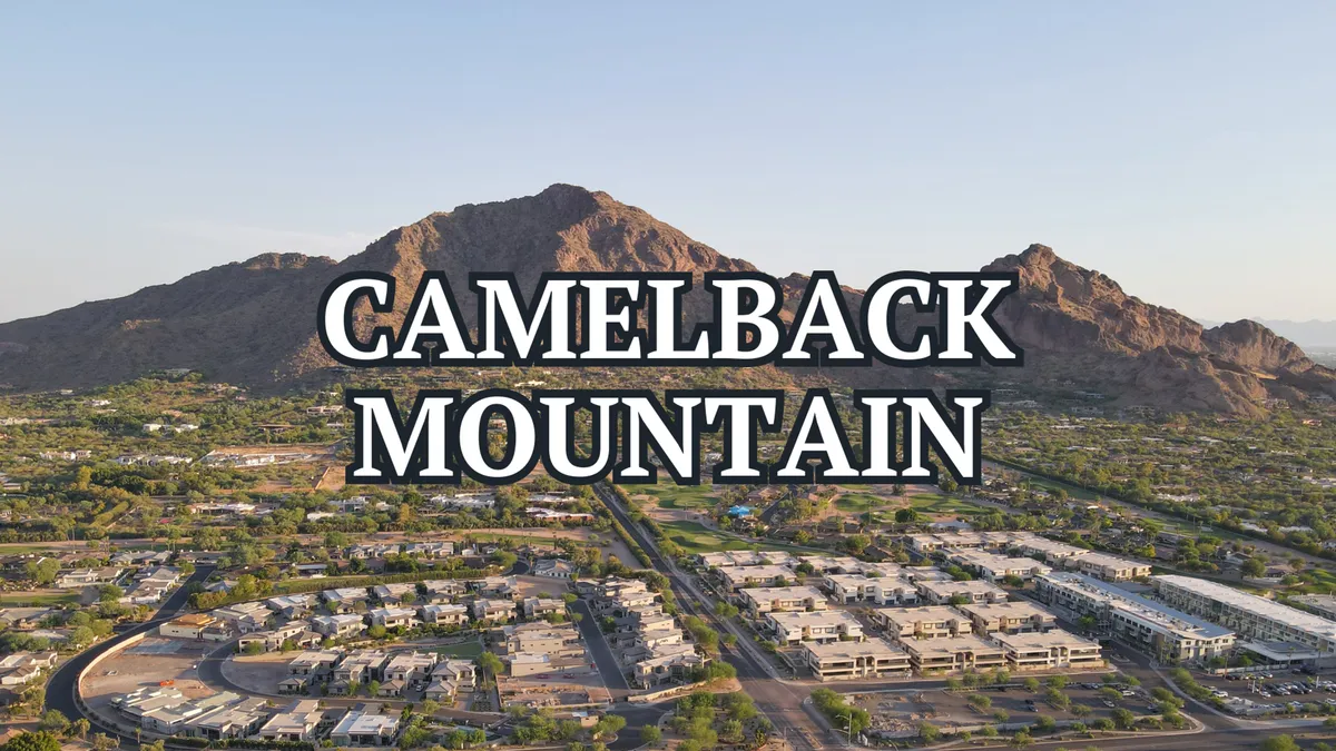 A sweeping view of Camelback Mountain with surrounding neighborhoods visible beneath a clear Arizona sky. The image features lush greenery and hints of local parks and open outdoor spaces, evoking the natural beauty and outdoor lifestyle that Scottsdale is known for.